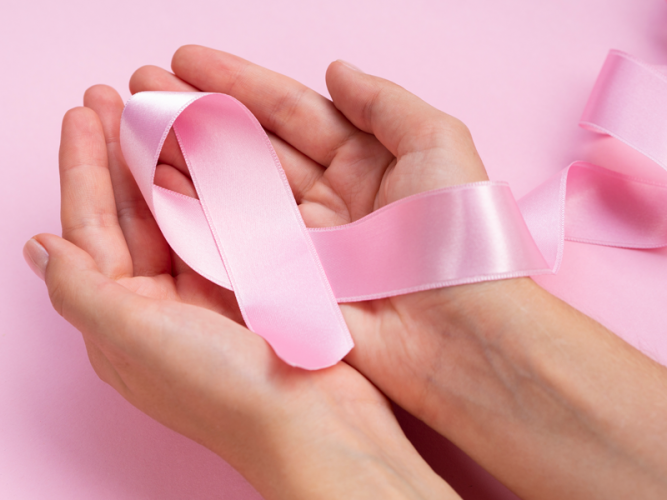 Outubro Rosa: mulher segurando fita rosa
